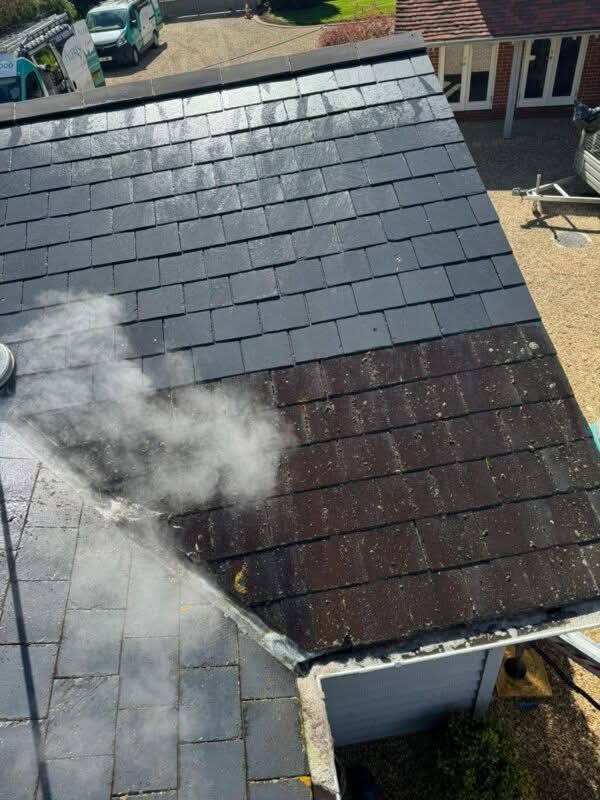Green-Ridge Roofing steam cleaning a slate-style tiled roof, treated section clearly cleaner